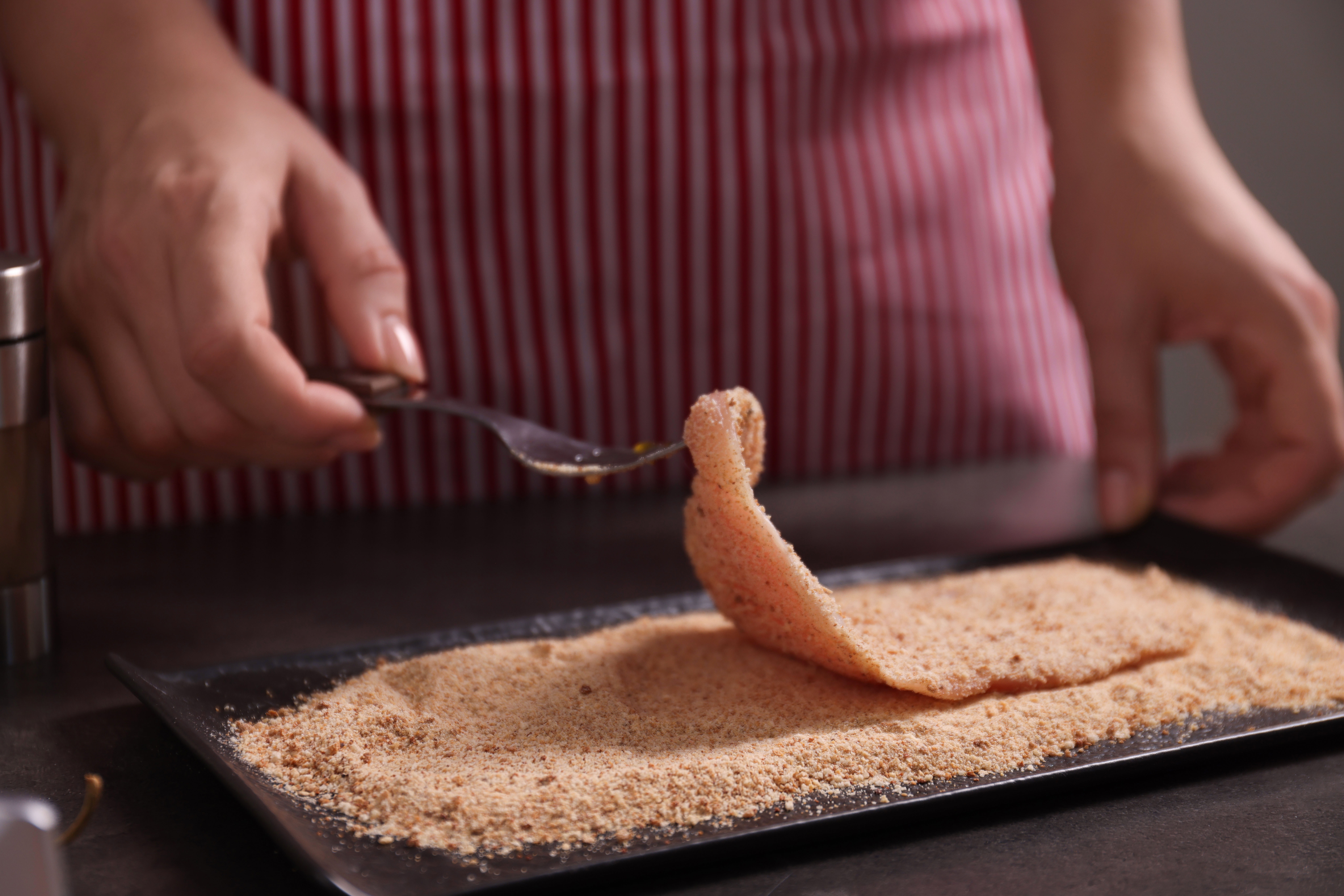 Hände panieren ein Schnitzel
